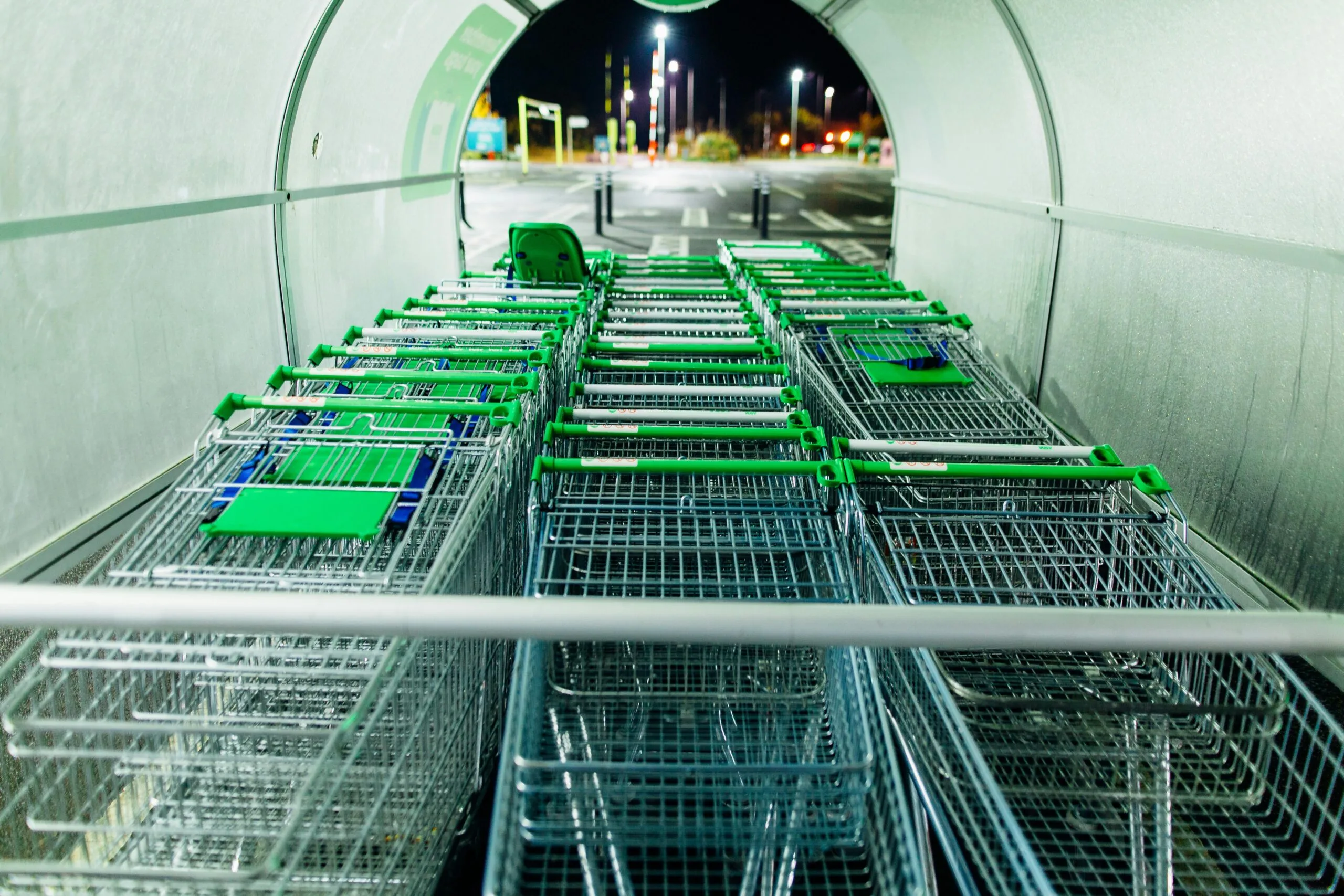 Shopping carts lined up in a retail store corridor representing the scale of retail and e-commerce operations